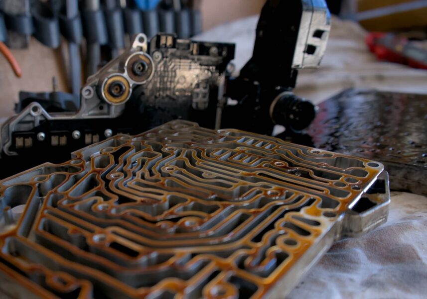 Dettaglio dei componenti interni di un cambio automatico smontato in officina, con canali idraulici e parti meccaniche in manutenzione.